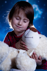 Time to sleep. Little cute child girl pretending mom, playing and puts teddy bear in bedю  Happy...