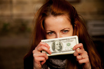 Business woman holding money as symbol of best motivation.