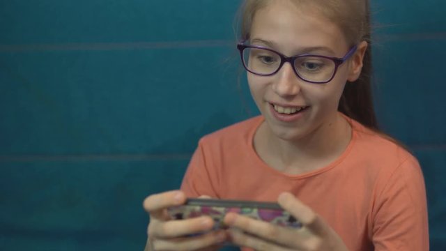 Teenager girl plays in a gadget with emotions