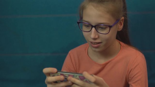 Young girl plays in a gadget with emotions