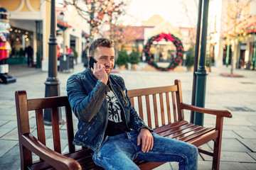 Fototapeta premium Young man sitting and talking over the phone