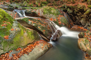Small mountain waterfall in autumn. A beautiful landscape full of peace. Looking at the mountain stream, you can relax and think. Bieszczady National Park Poland