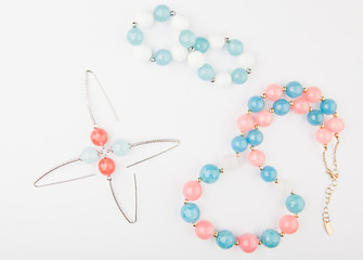 silver earrings pink blue agate stone beads ceramic bracelet white background 
