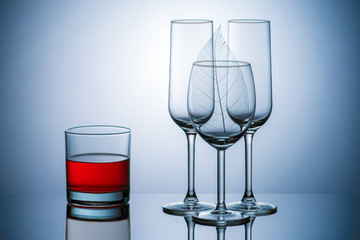 transparent glass goblets, rum, wine, blue background