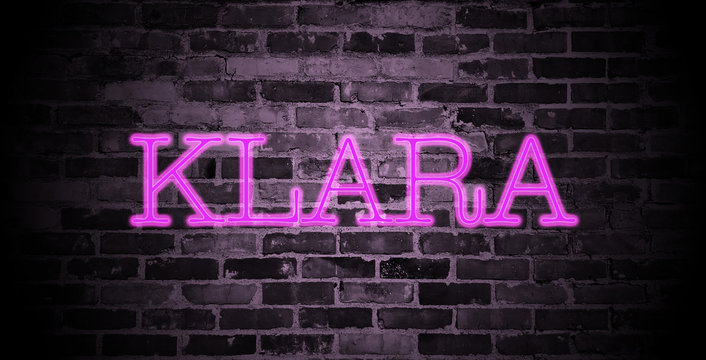 first name Klara in pink neon on brick wall