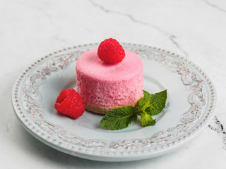 Round pink mini cheesecake with raspberry and mint