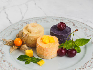 Round orange mini cheesecakes with friuits and berries