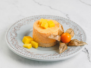 Round orange mini cheesecake with exotic friuits and mint