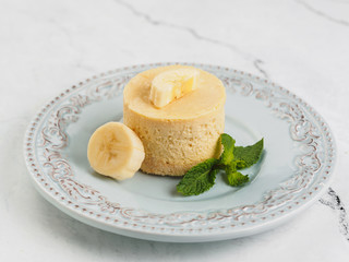 Round yellow mini cheesecake with banana and mint