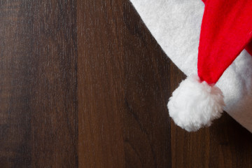 Obraz na płótnie Canvas Die Mütze des Weihnachtsmanns hängt an einer Holzwand