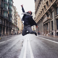 Un chico joven salta en el medio de la calle Via Laietana de Barcelona en un día lluvioso