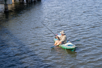 man fishing in a lake in a kayak