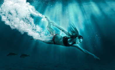 Athletic girl diver alone in the depths of the ocean