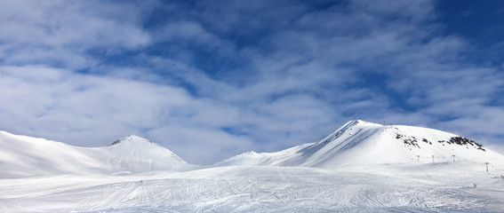 Ski slope with print from skis, snowboards and foot, snowy mountain