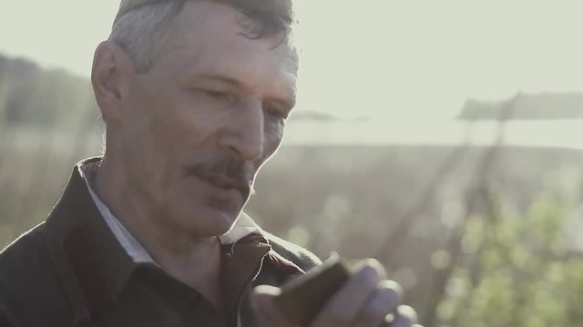 A Soviet soldier from World War II holds a gold bar in his hands, examines it from all sides, admires, gold glitters on his face, a soldier found a treasure, gold of the Third Reich