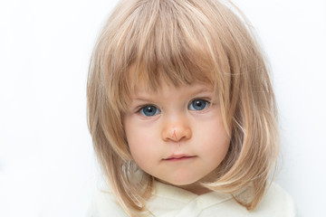 Blue-eyed blond baby with Bob hair and scratched nose close-up. Isolated on white. Female child looking seriously at camera in white studio, frowning eyebrows. Negative emotions, displeasure, offence.
