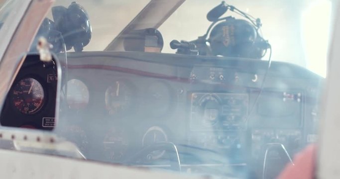 Detailed shooting of a small passenger plane in the hangar, close-up details, panorama of the surf, hands hold the steering wheel, dashboard, steel propeller, chassis, gauges