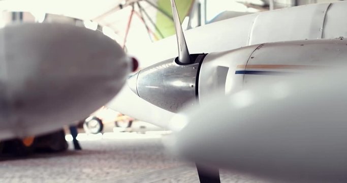 Detailed shooting of a small passenger plane in the hangar, close-up details, panorama of the surf, hands hold the steering wheel, dashboard, steel propeller, chassis, gauges