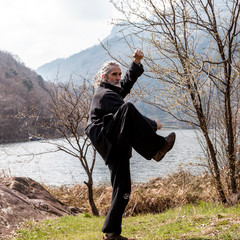 mature man practicing Tai Chi discipline outdoors