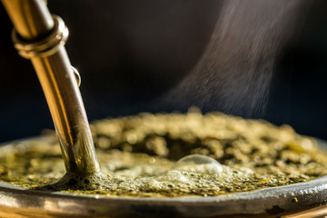 Steaming delicious yerba mate in a traditional calabash gourd, horizontal closeup.