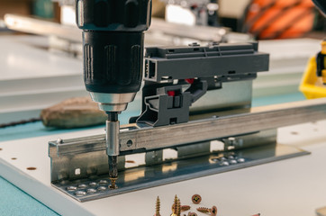 Assembling furniture from chipboard, using a cordless screwdriver