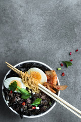 Korean ramen soup with minced meat , egg, asian mushroom and kimchi on a grey neutral background. Flat lay. copy space.