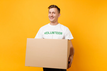 Portrait of good kind man in white t-shirt with written inscription green title volunteer with big...