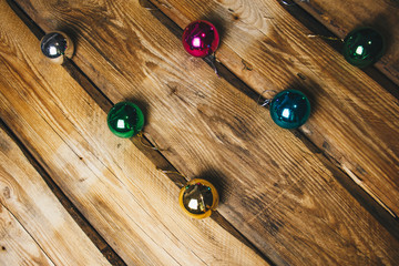 Colored christmas decorations on rustic wooden table. Xmas balls on wood background. Top view, copy space