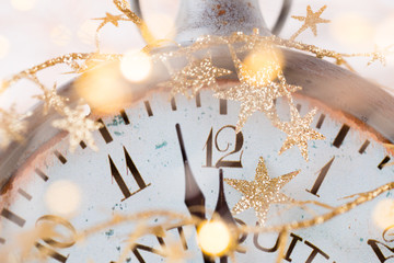 vintage alarm clock is showing midnight. It is twelve o'clock, christmas and bokeh, holiday happy...
