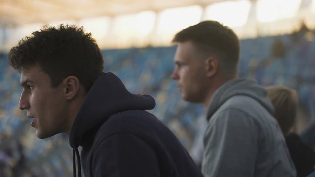 Male Fans Anxiously Watch Sport Game At Stadium, Rejoice Victory And Embrace