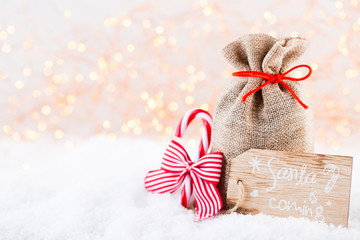 Christmas greeting card. Christmas tree branch on glitter golden bokeh lights background. New Year concept. Copy space.