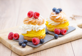 Cake with biscuit and berries and sprinkle on a substrate on a colored background.