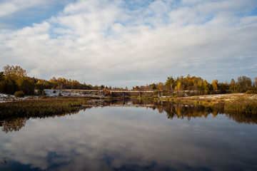 cold and calm morning view by the lake with first snow in winter