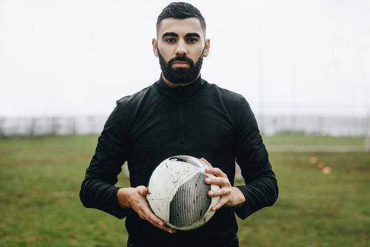 Portrait of a soccer player standing on field holding a ball
