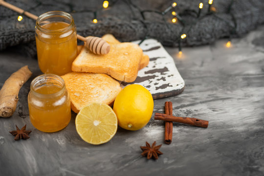 Jam with lemon and ginger with toasts and spices on a dark background, with space for an inscription. The concept of heat, recommendations for health and support of immunity and the immune system