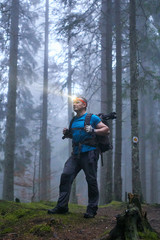 Man with headlamp and backpack in the forest