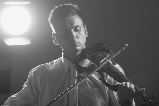 The musician plays the electronic violin. Violin close up.