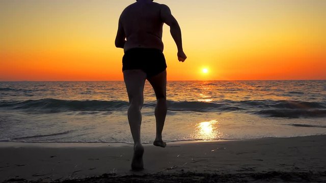 Man run and jump into sea sunset water with splashes, SLOW MOTION