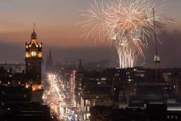 View of Princess Street, Edinburgh, from Calton Hill at dusk, with lights on and firework display...