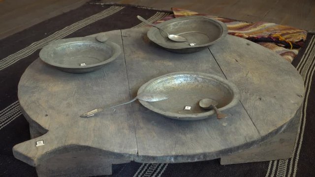 Kas, Antalya, Turkey - 18th of May, 2017: 4K In the Kas museum of ethnography - Museum specimens: metal plates with spoons on wooden round table