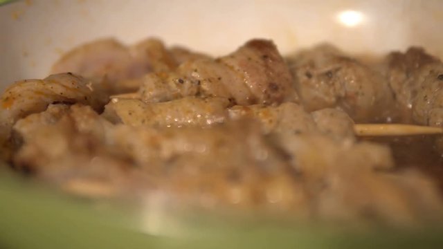 Skewers of meat with vegetables cooked on a spit in a pan