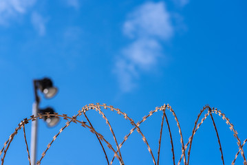 barbed wire against the sky and spotlights