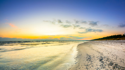 Sunrise at the ocean with shells on the beach