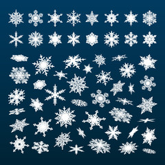 Big set of white snowflakes falling in different perspective, angles,directions isolated on dark blue night sky background. Vector illustration.
