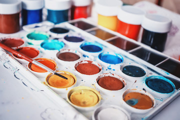 Close-up of color paints with a brush. Paints used by the artist, prepared for drawing