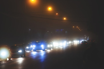 car lights at night on a wide foggy road