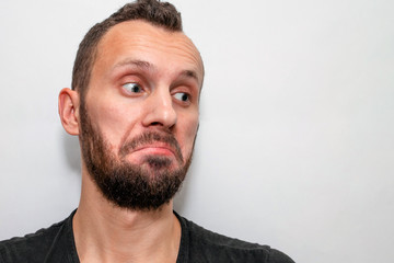 Obraz premium portrait of a young bearded guy with a surprised and astonished face, copyspace