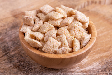 Crispy corn pads in wooden bowl with burlap napkin