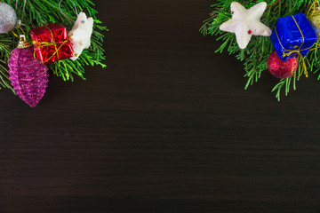 Christmas ornaments and pine tree branches on corner of wooden background. Brown blank aerial;