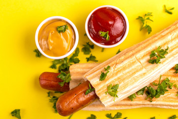 Two grilled french hot dogs with mustard and ketchup